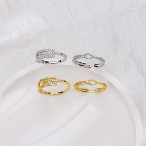 Detail view of 925 stamped gold and silver knot rings with pavé zircon on a white stand