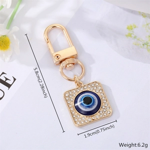 Detailed view of evil eye keychain with gold finish, blue crystal inlay and dimensions