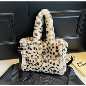 Detail of leopard print plush tote bag featuring soft faux fur and black shoulder strap
