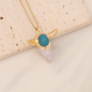 Macro detail of bohemian bull head pendant with turquoise stone on natural stone