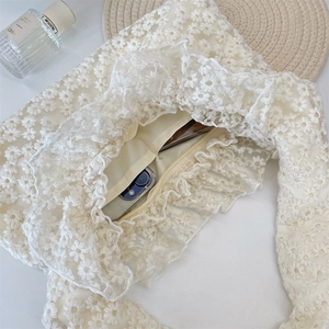 Detail of white lace daisy handbag with ruffled edges and secure zipper closure