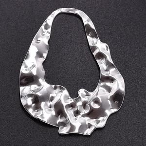 Macro view of silver hammered texture on an irregular stainless steel pendant piece