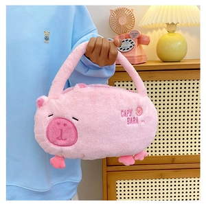Person holding a pink plush capybara character handbag in a cozy home setting
