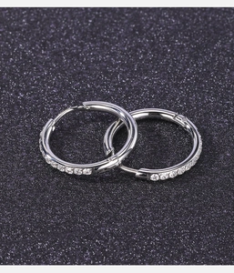 Dettaglio di orecchini a cerchio in acciaio inossidabile argento con pavé di zirconi