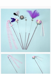Detail view of cat teaser wand featuring soft feathers ribbons and glitter handle decoration