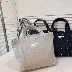 Detail of polka dot and striped denim canvas tote bags with simple wish labels