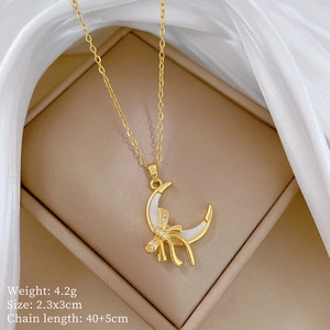 Close-up of golden moon and bow pendant on jewelry box with 4.2g weight specs