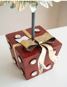 Detail of red metal gift box base with golden bow and crystals for Christmas decor