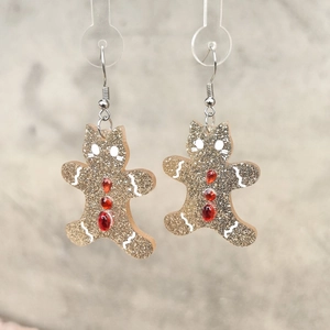 Détail des boucles d'oreilles chat pain d'épices en acrylique pailleté doré et cristaux
