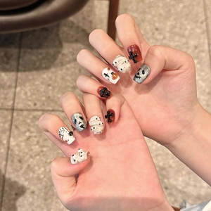 Halloween press-on nails featuring 3D mummy, skull, and cross designs in black and red