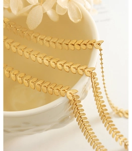 Detailed close-up of 18K gold-plated leaf chain with elegant brushed metal texture
