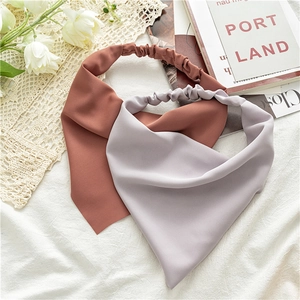 Detail of red-brown and light gray chiffon elastic headbands on decorative background