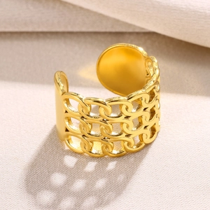 Detailed close-up of triple-row gold hollow chain open ring on beige textured fabric