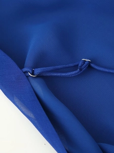 Détail de la bretelle de robe en mousseline bleue avec anneau de réglage en métal