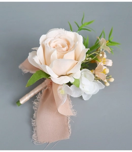 Détail de la boutonnière faite main rose champagne avec ruban mousseline et feuilles