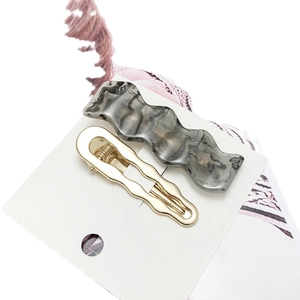 Gray marble acrylic clip and wavy gold metal hairpins set on white display card