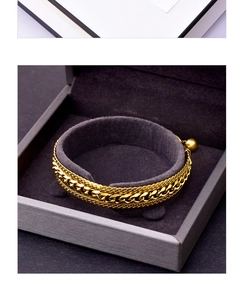 Macro shot of gold layered snake chain bracelet with ball charm in jewelry box