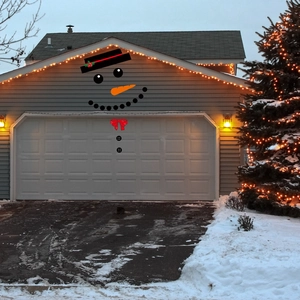 Outdoor Christmas snowman garage door decal kit featuring a hat and carrot nose decoration