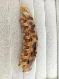 Detail view of large amber tortoiseshell banana hair clip with dense comb teeth