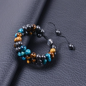 Macro shot of triple-layer 8mm tiger eye and hematite stone beads on leather background