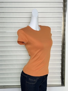 Side view of fitted orange short sleeve T-shirt showing hourglass waist and slim cut