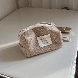 Macro detail of tweed herringbone storage bag with color dots and white resin zipper