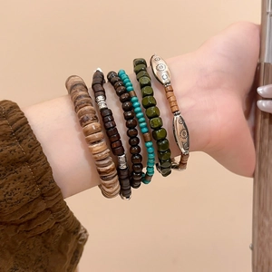 Detailed close-up of stacked ethnic wooden bead bracelets with vintage sun carving