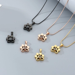 Détails de pendentifs en forme de patte en finitions noir, doré et or rose