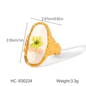 Macro detail of 18K gold stainless steel ring featuring hammered texture and dried flowers