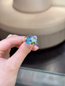 Close-up of geometric gold ring featuring multi-colored cubic zirconia stones