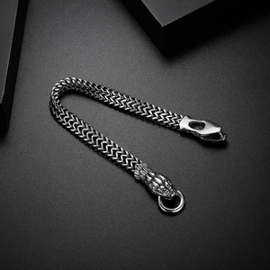 Vintage stainless steel double snake head woven bracelet on premium dark background