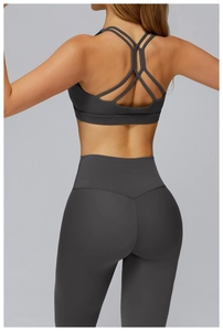 Detail of cross-strap back design and V-shaped stitching on dark grey yoga set