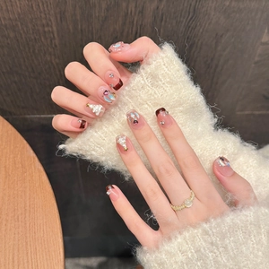Detail of French Christmas press-on nails with 3D resin trees and pearl ornaments