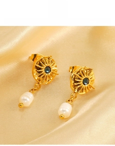 Detail of titanium steel starburst earrings with blue gem and teardrop pearl on silk