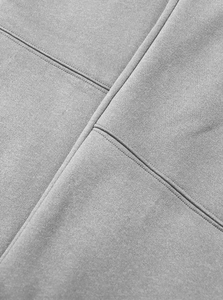 Detailed close-up of grey fleece fabric showing precision stitching and patchwork design