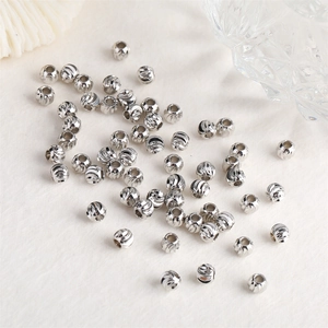 Detailed close-up of silver-plated spiral-textured round spacer beads for jewelry making
