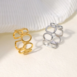 Close-up of geometric hollow cut-out rings in gold and silver stainless steel finish