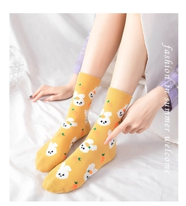 Close-up of yellow mid-calf socks with cute white bunny and orange carrot patterns