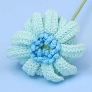 Detailansicht einer handgehäkelten hellblauen Gerbera aus Wolle mit feiner Textur