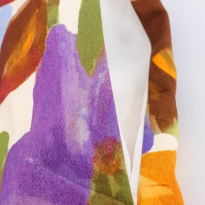 Vue macro du tissu à imprimé floral montrant la texture du lin et les coutures de la robe