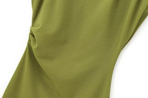 Detail of grass green dress showing ruched waist design and premium polyester texture