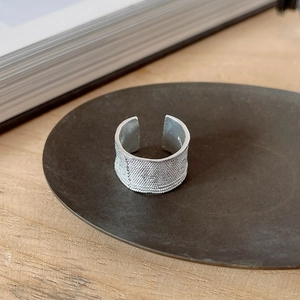 Detailed macro shot of irregular texture on silver S925 ring on a metal tray