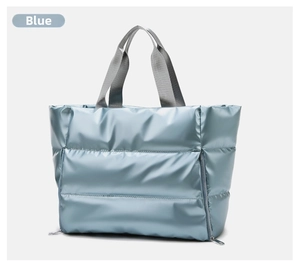 Detail of light blue quilted fitness bag with gray straps and vertical zipper pockets