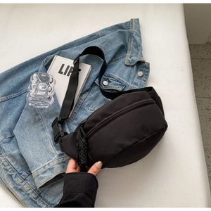 Dettaglio della borsa a tracolla minimalista in nylon nero con tiralampo intrecciato