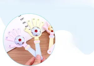 Macro detail of macaron-colored palm-shaped baby rattle with rotating football module