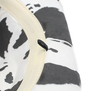 Detail view of the inner lining and beige sweatband on a faux suede cow print cowboy hat