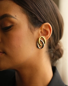Detail of two-tone double hoop earrings in polished gold and silver on a female model