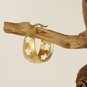 Boucles d'oreilles créoles en acier doré avec étoiles ajourées sur une branche en bois
