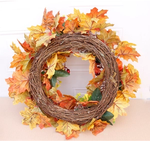Close-up of fall wreath featuring orange maple leaves, red berries, and natural pine cones