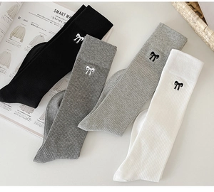 Detailed view of four pairs of ribbed knit socks with small bow embroidery accents